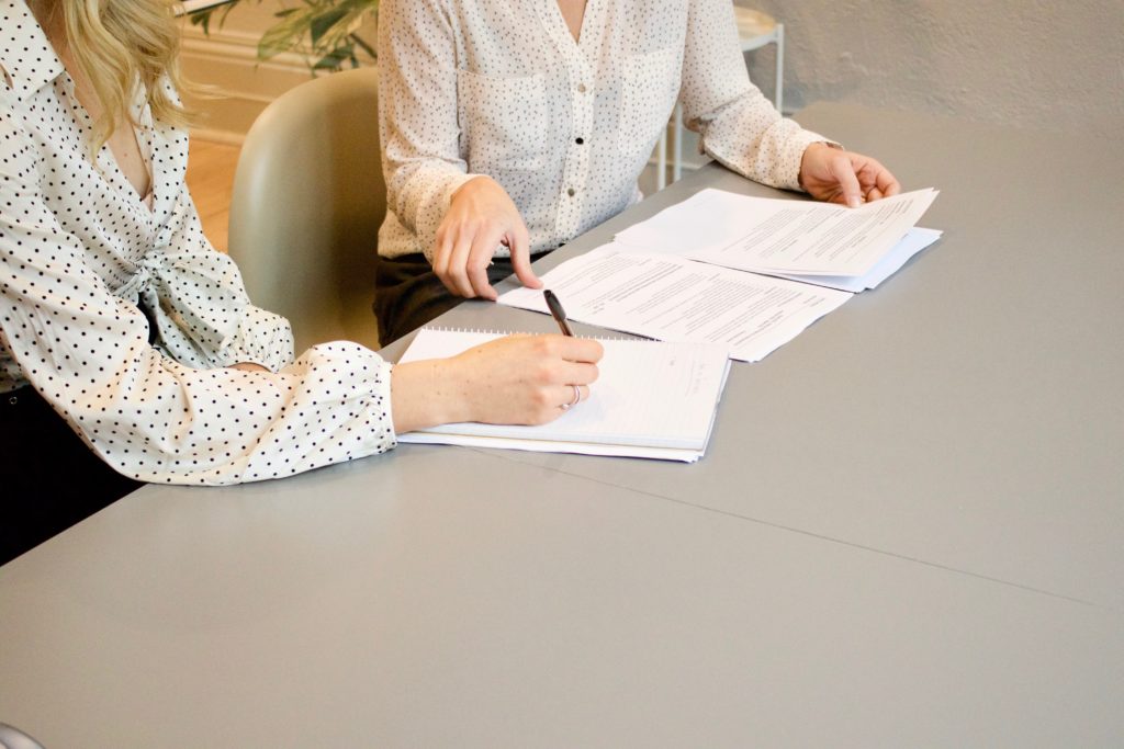 Picture shows two women going over resumes that show different experience.