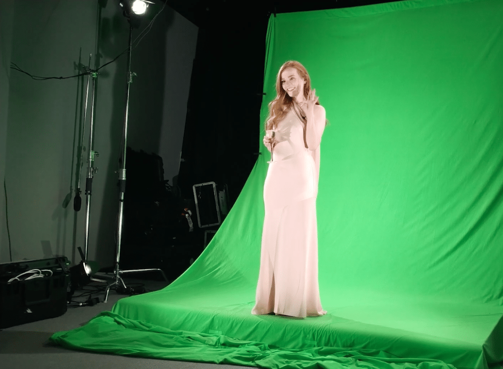 Photo shows a bridesmaid standing in front of a green screen in order to make a hologram visit.