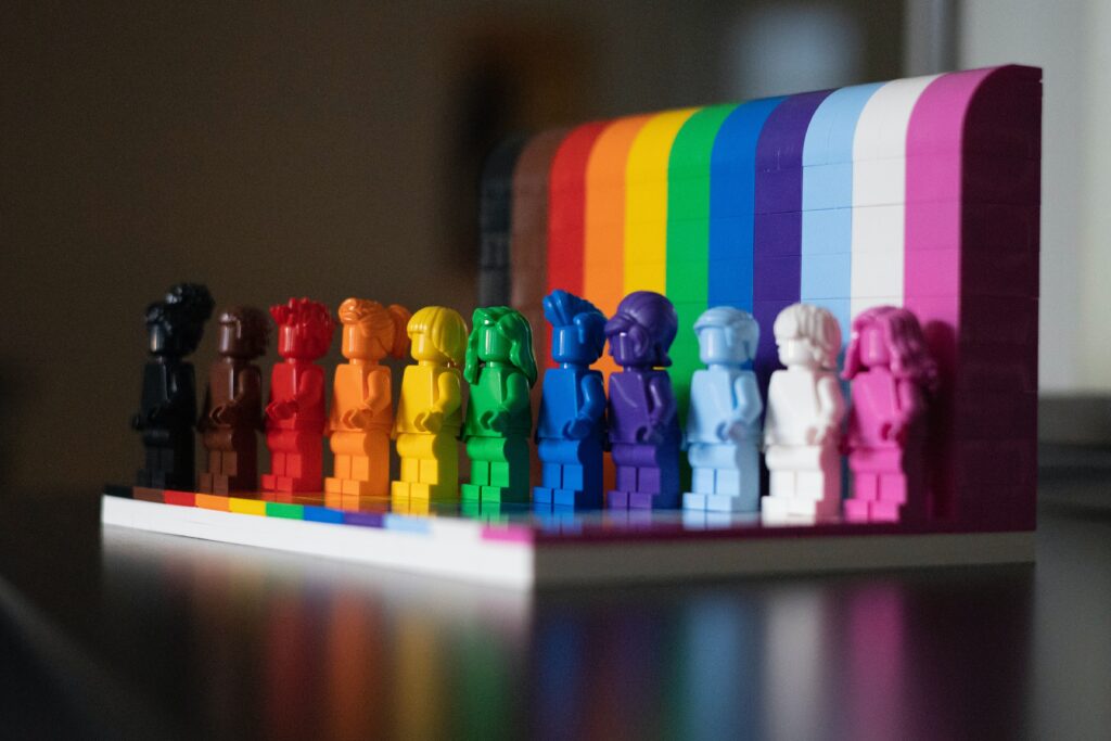 A rainbow of LEGO bricks and mini-figures shows a range of colors and also celebrates pride month.