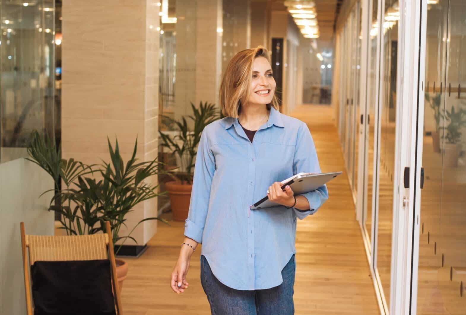 Image of a woman walking in hallway looking refreshed after a break.