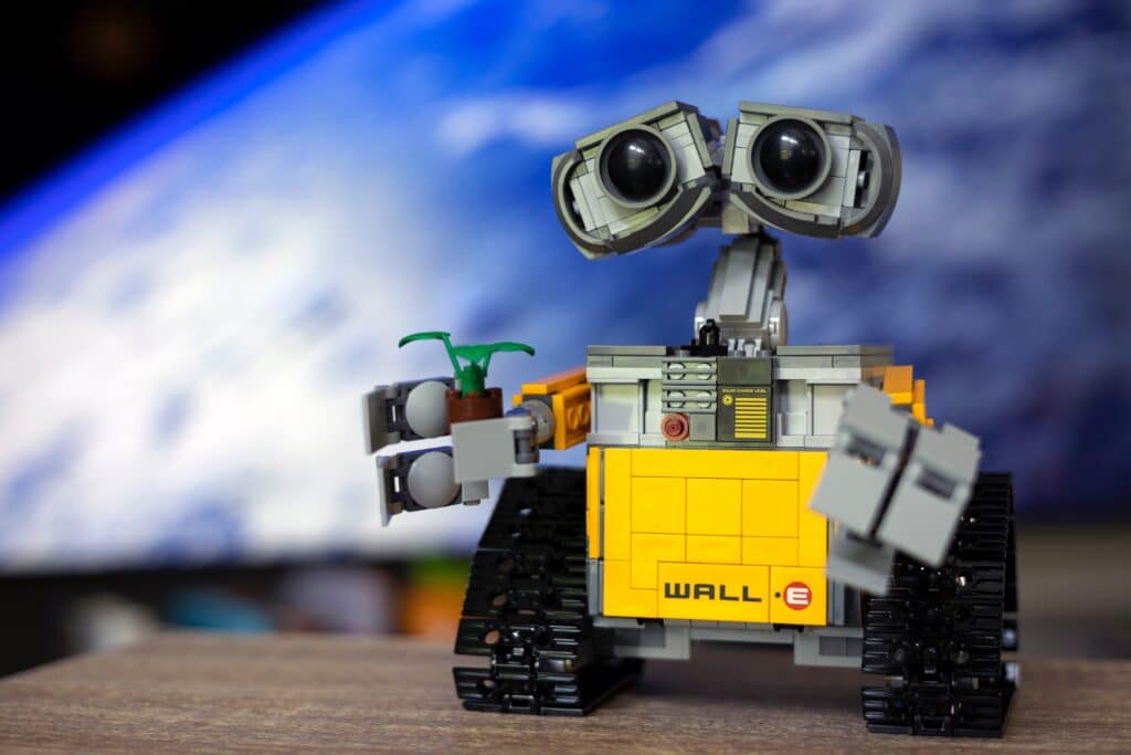 Image of WALL-E holding a plant alludes to AI's carbon footprint.
