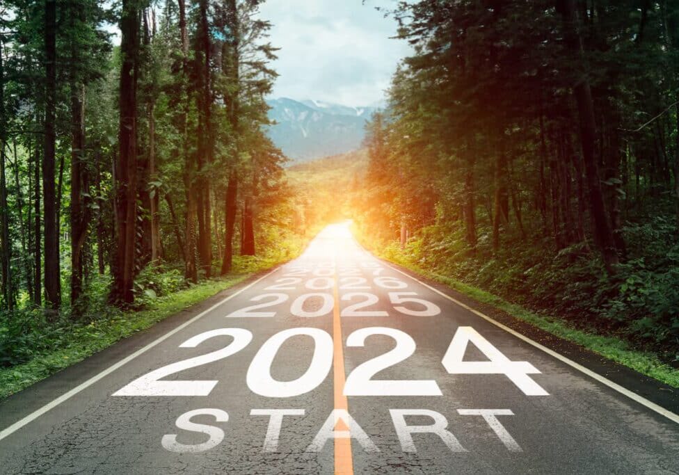 New year 2024 or 2024 planning concept of success beginning. Text 2024 written on the middle of paved road with sunset. New year plan, goals, challenges, resolutions.