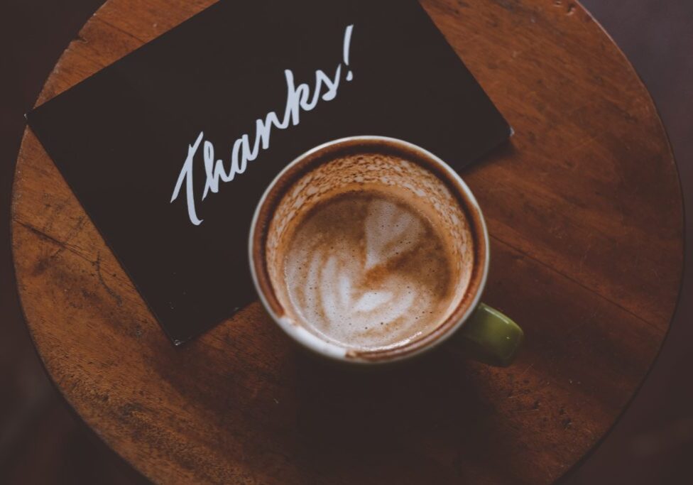 Image of a cappuccino and thank-you note show a great example of gratitude at work.