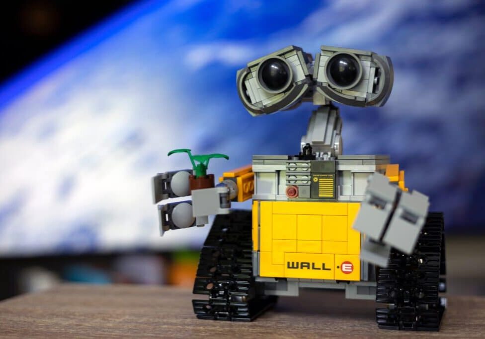 Image of WALL-E holding a plant alludes to AI's carbon footprint.