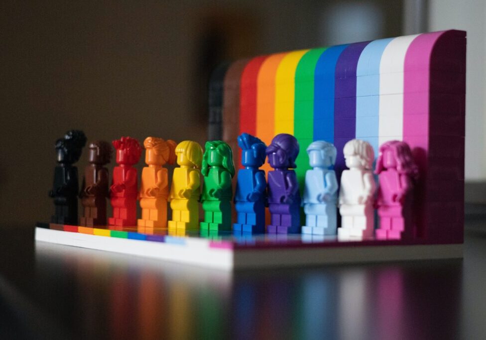 A rainbow of LEGO bricks and mini-figures shows a range of colors and also celebrates pride month.