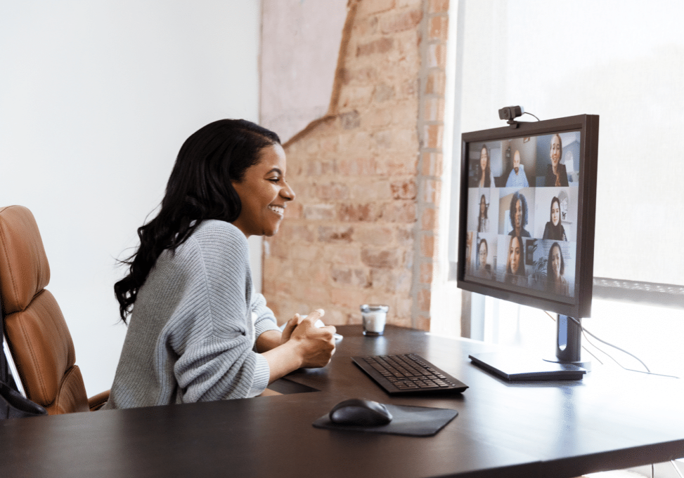 Image: A woman using Microsoft Teams Essentials looks happy about the new lower-priced option.